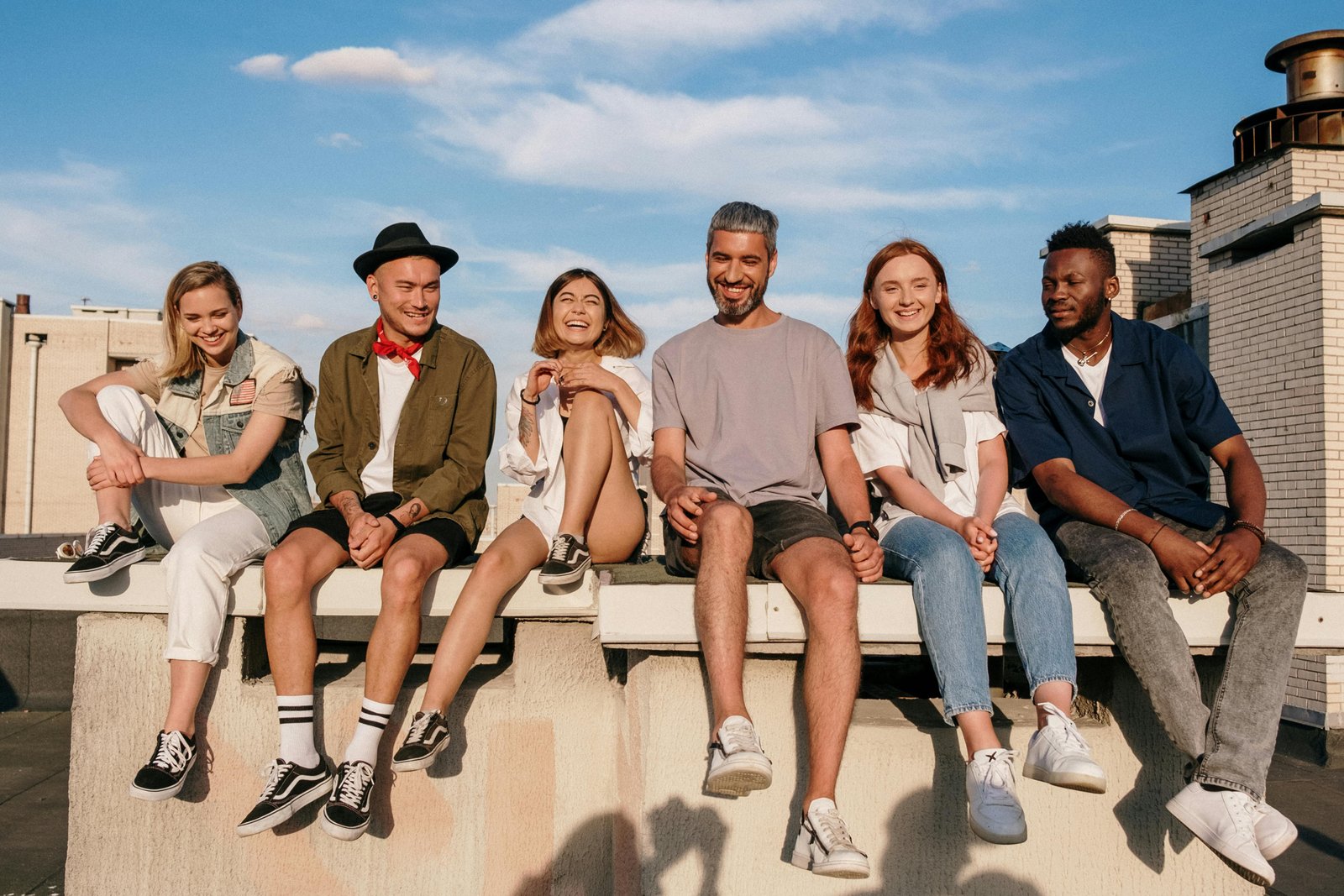 Young people sitting in the sun on a walk, talking casually